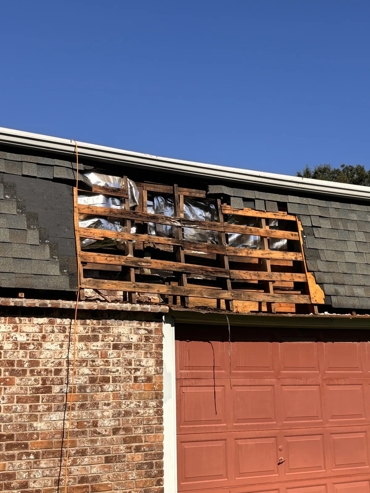Exposed wooden roof framing before repair