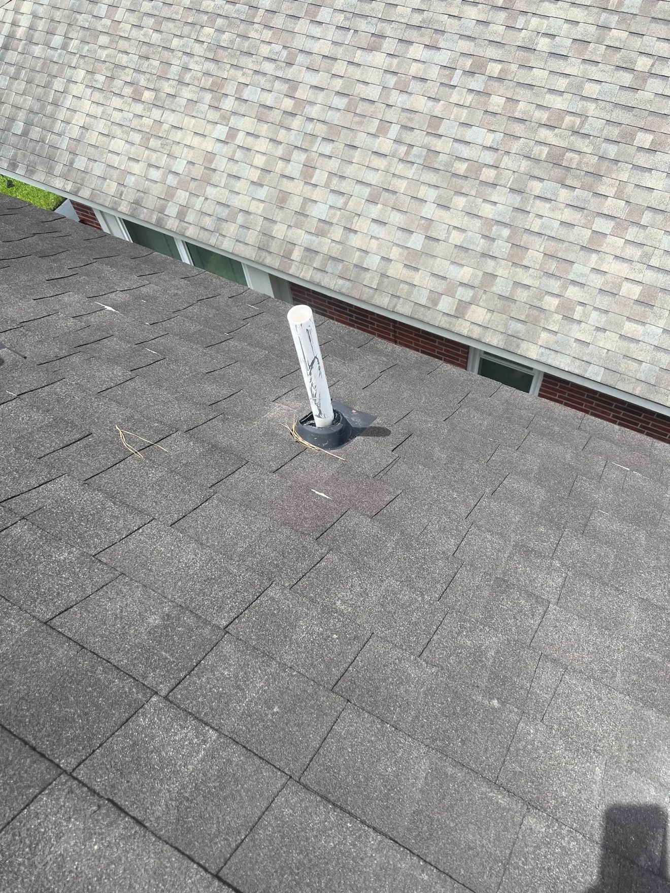 Worn vent pipe boot with cracked rubber seal on an asphalt shingle roof